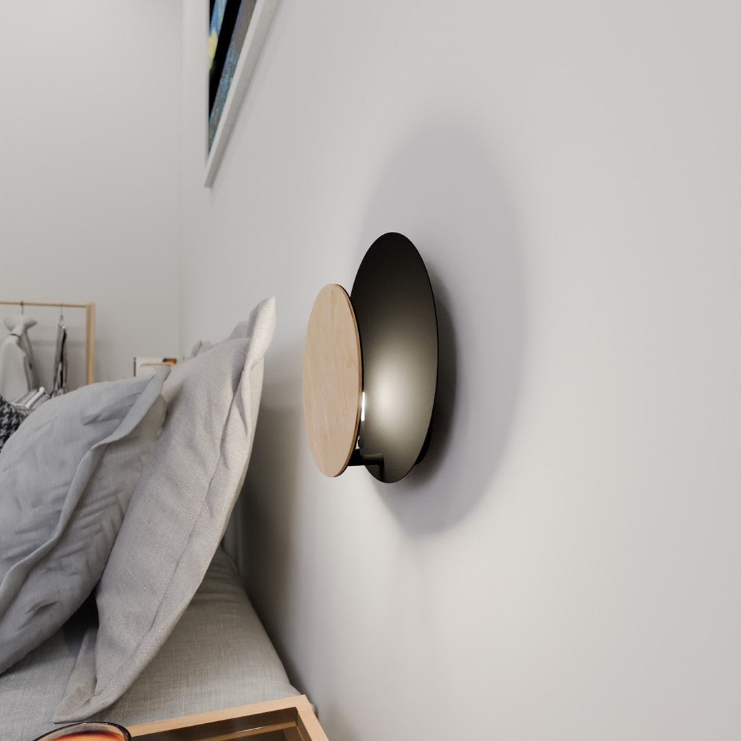 Applique allumée de nuit, halo lumineux diffusé sur le mur blanc