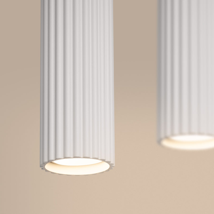 Détail rapproché du bas d'un cylindre allumé, lumière chaude et stries verticales