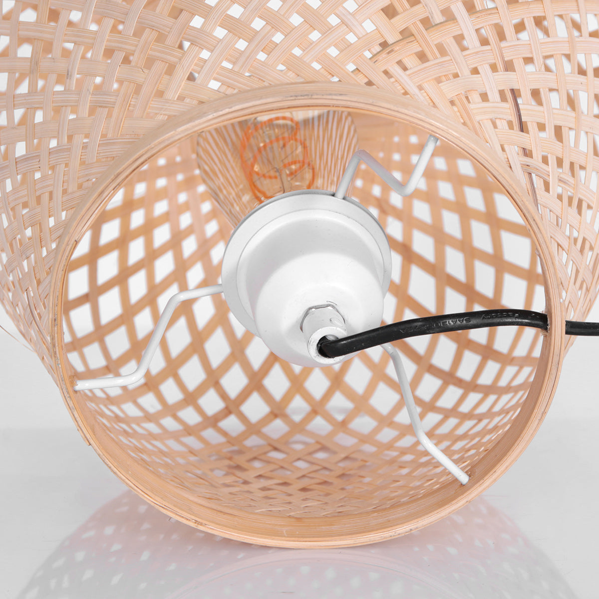 Lampe à poser bambou Maze allumée, jeu d'ombres du tressage sur le mur