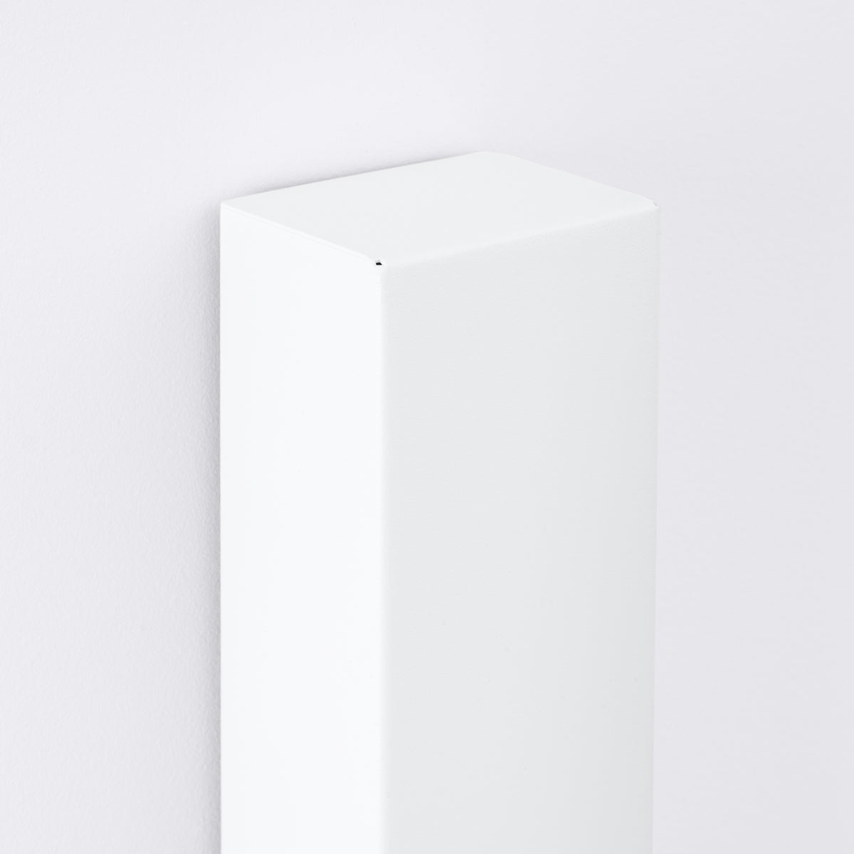 Détail rapproché du sommet biseauté à facettes du caisson blanc.