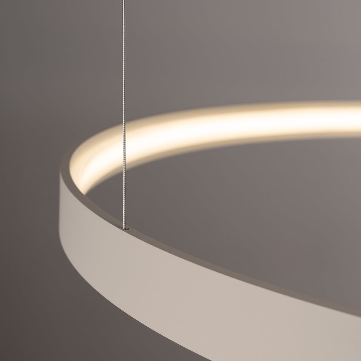 Détail rapproché d'un câble en acier traversant l'anneau et diffusant une lumière chaude.