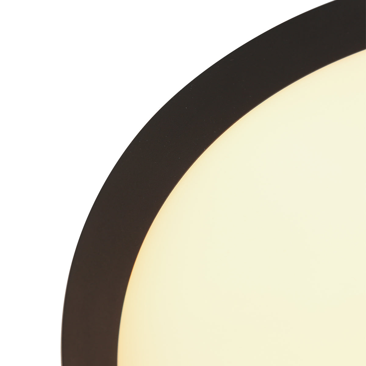 Gros plan sur le bord noir et le diffuseur lumineux du plafonnier