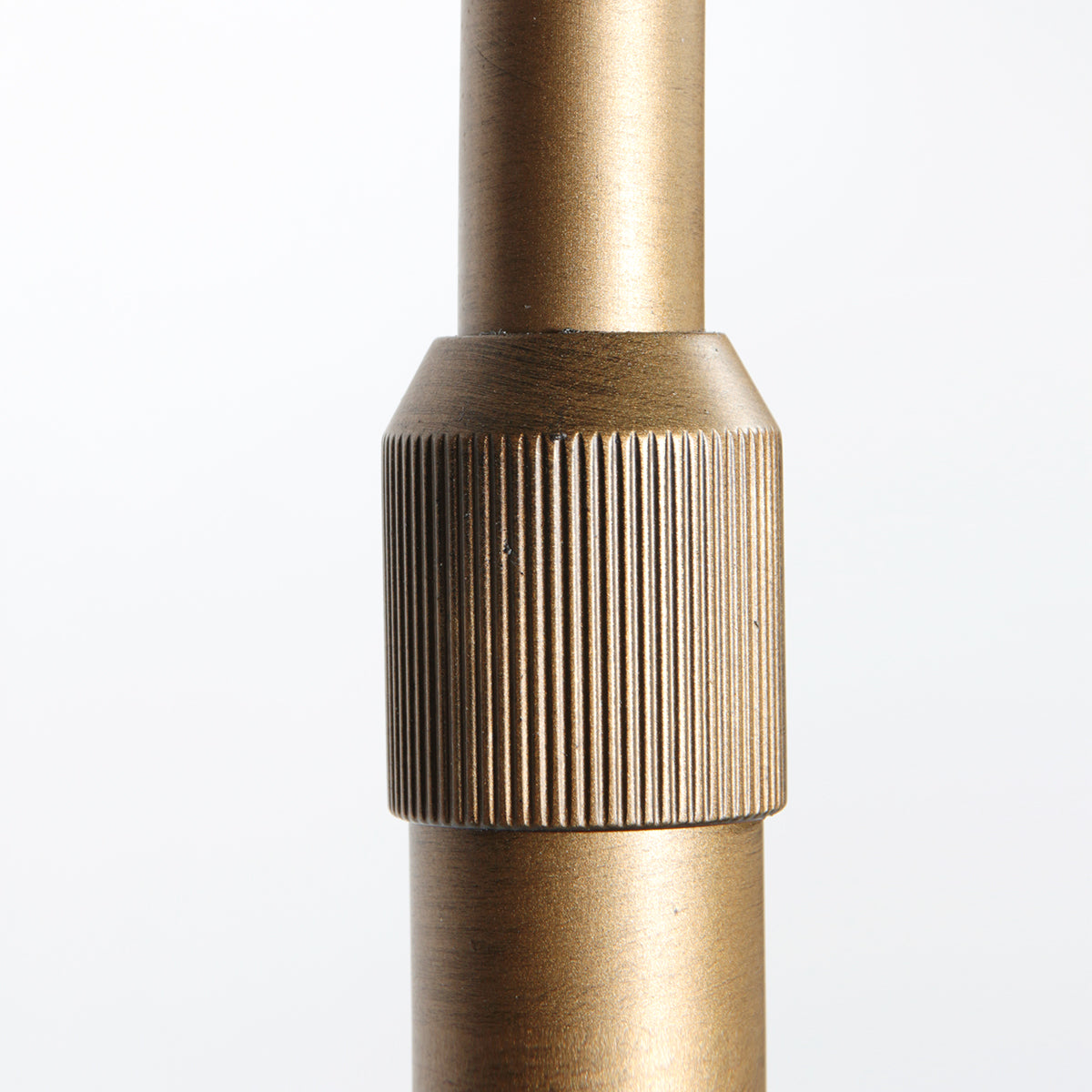 Détail de la tige cannelée bronze du lampadaire arc – Designix.fr