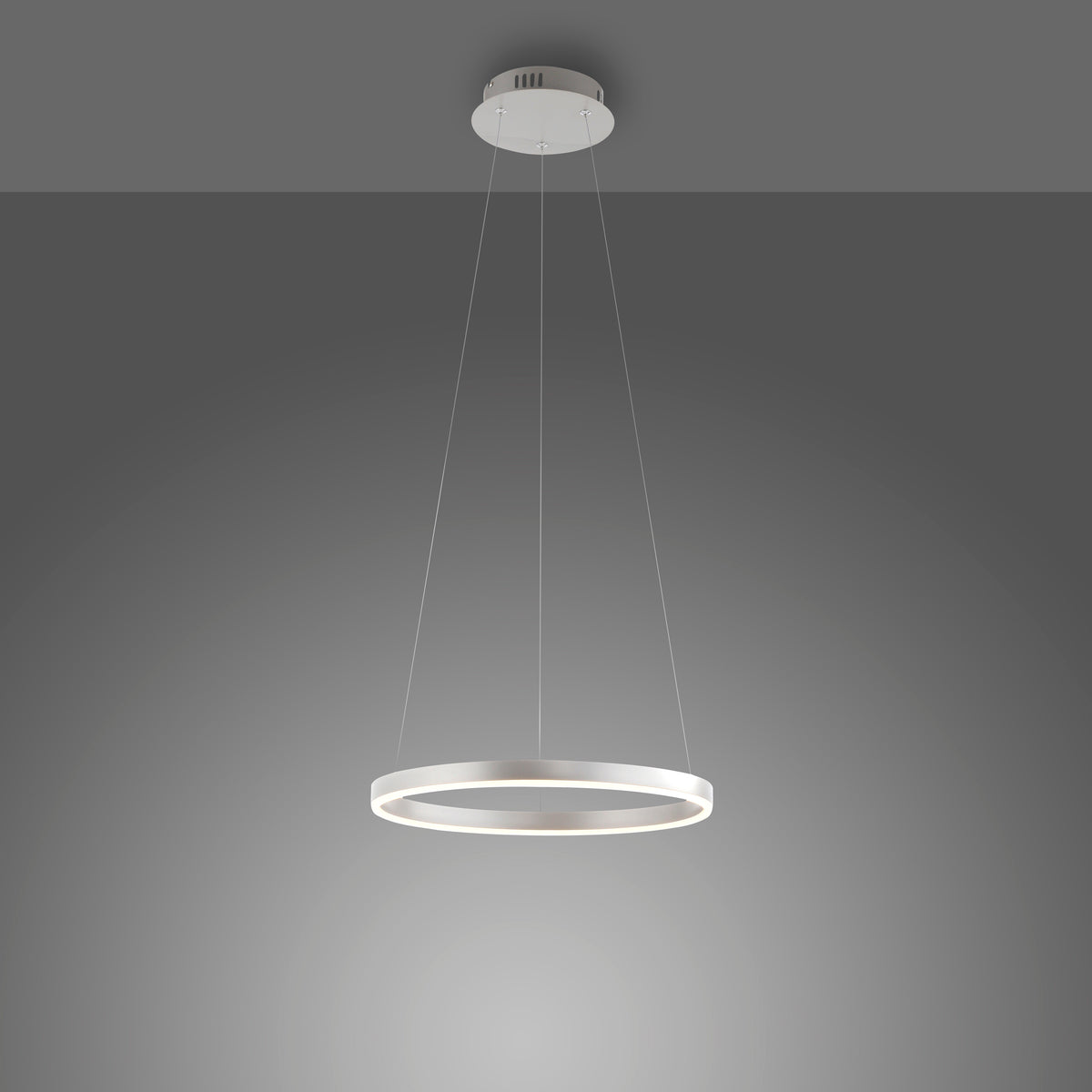 Autre vue de la suspension ronde en aluminium sur fond dégradé gris, éclairage allumé.