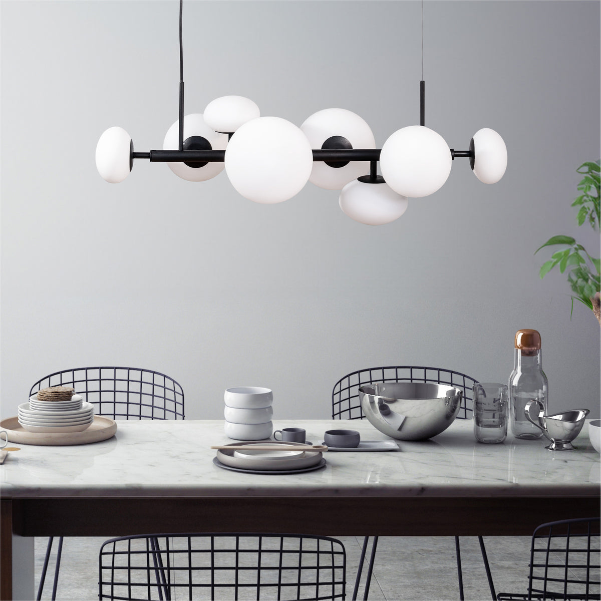 Suspension installée au-dessus d'une table à manger en marbre, dans une salle à manger moderne.
