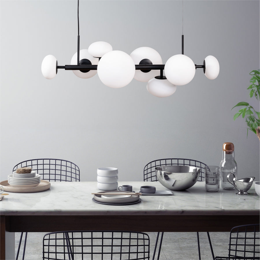 Suspension installée au-dessus d'une table à manger en marbre, dans une salle à manger moderne.
