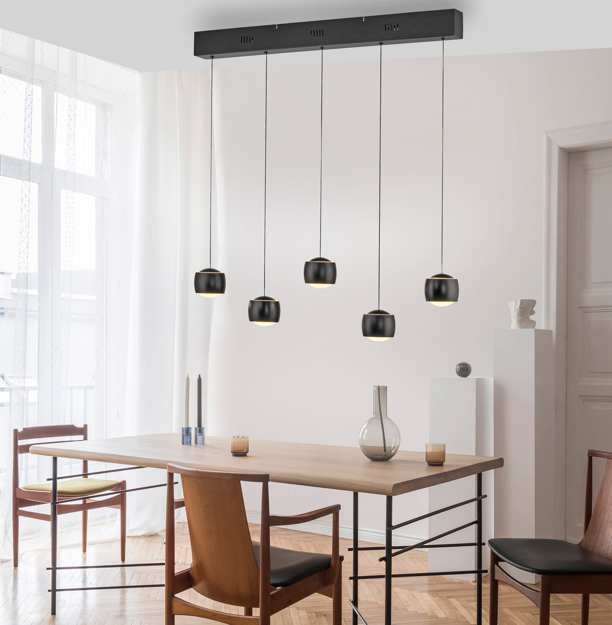 Mise en ambiance au-dessus d'une table à manger en bois dans un intérieur clair