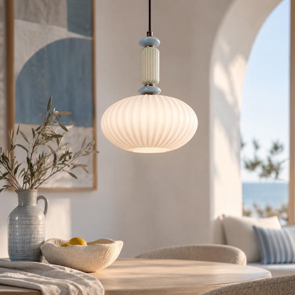 Suspension éclairée au-dessus d'une table en bois, décor méditerranéen avec vase et arche.