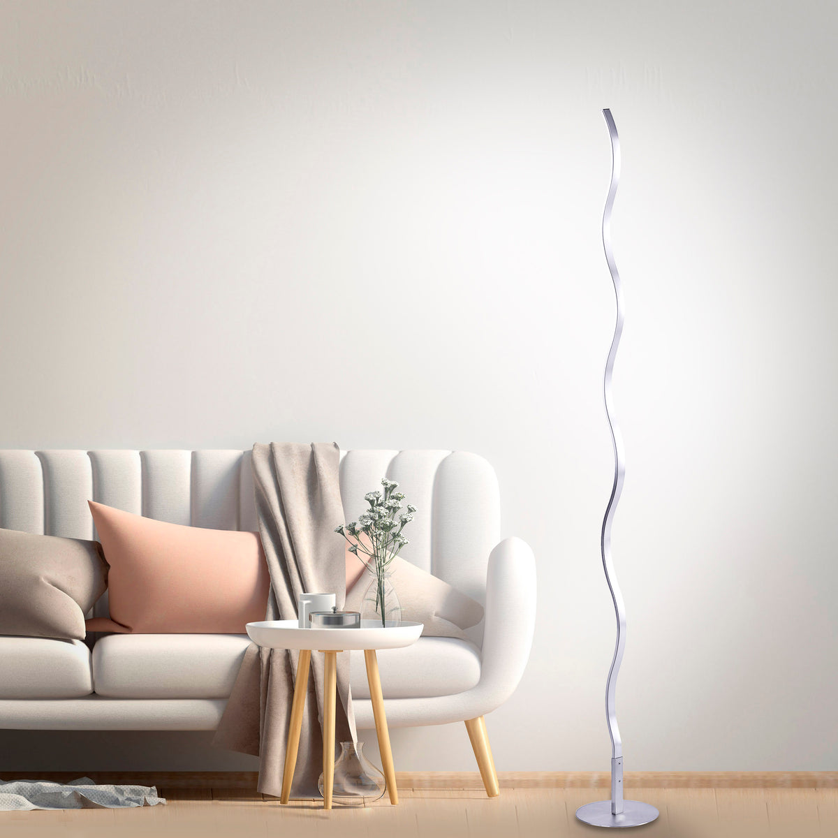 Mise en ambiance salon clair : lampadaire ondulé allumé près d'un canapé blanc.