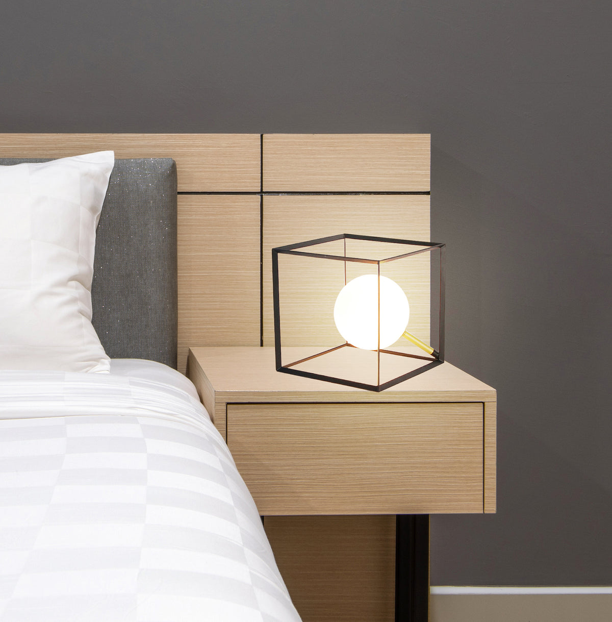 La lampe allumée près d'un lit, cadre noir et globe lumineux