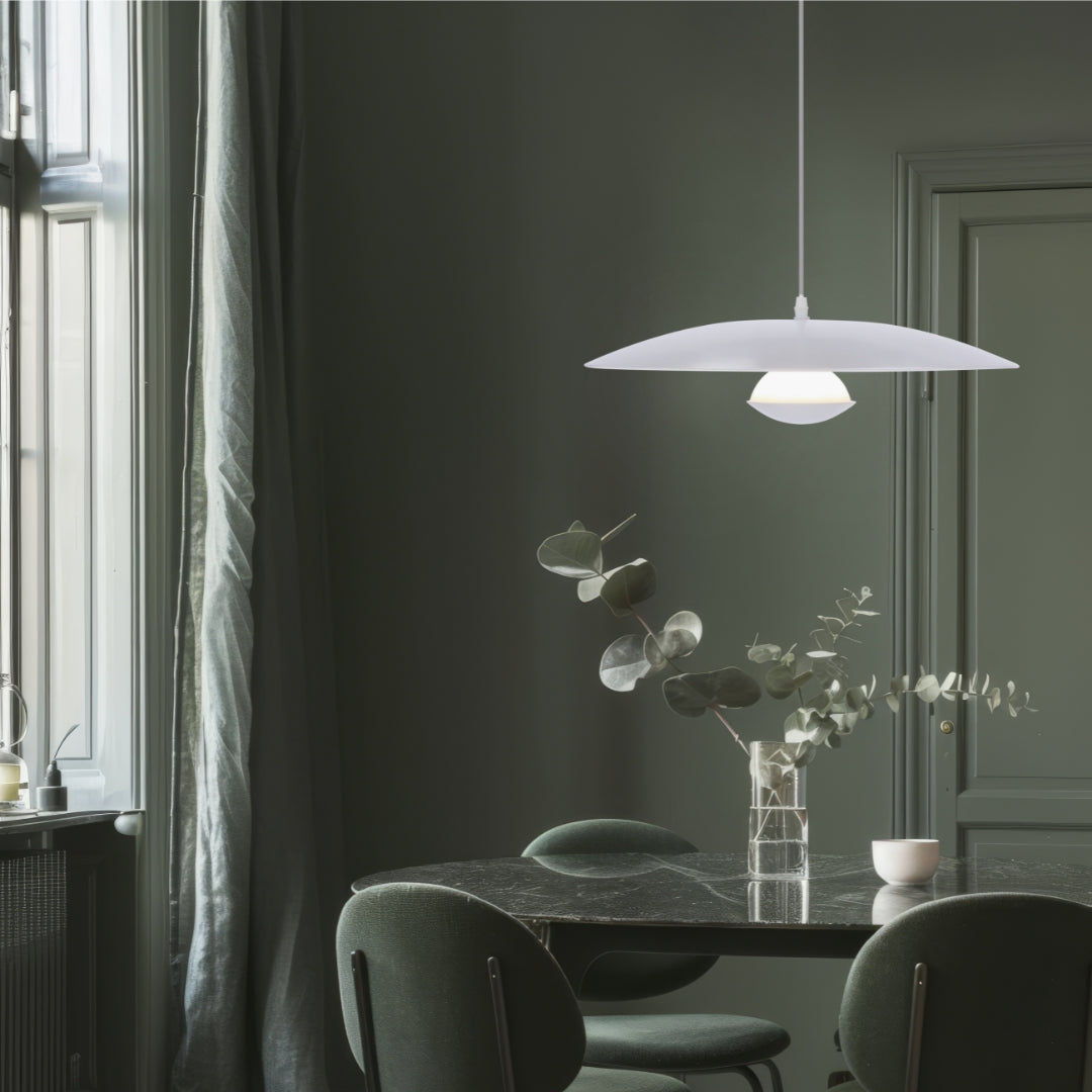 Mise en ambiance au-dessus d'une table ronde dans une salle à manger aux murs verts.