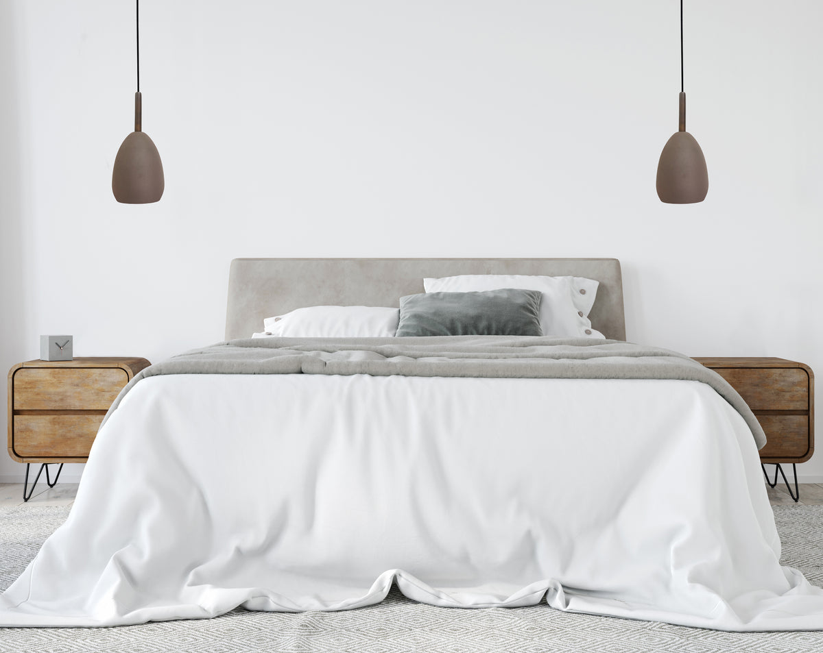 Ambiance chambre claire, deux suspensions marron suspendues de part et d'autre du lit