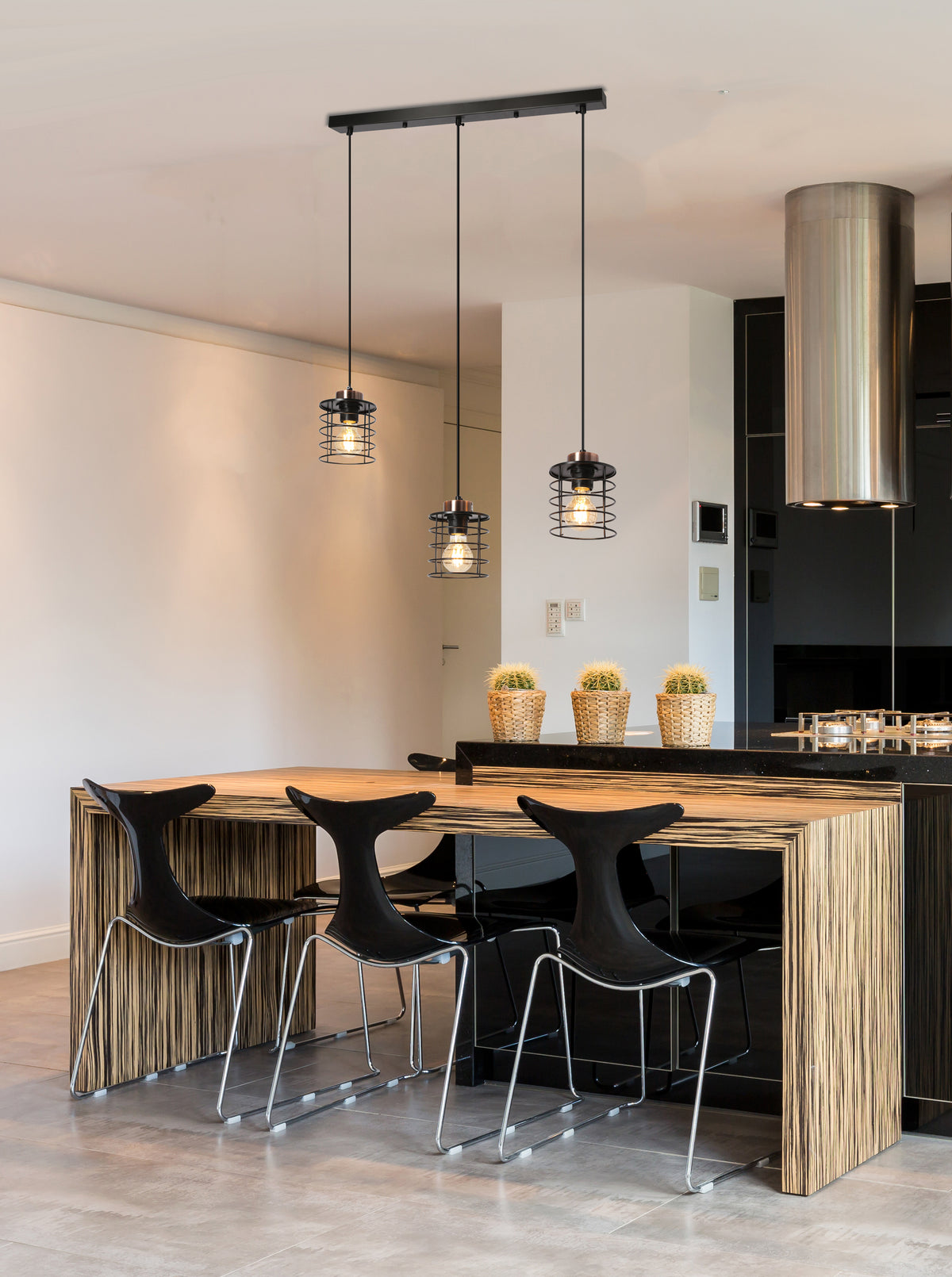 Mise en ambiance du salon, suspension allumée au-dessus d'une table en bois clair