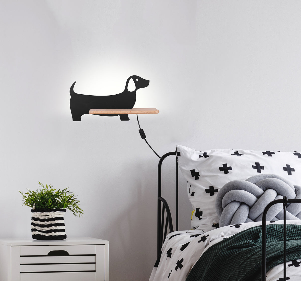 Mise en ambiance dans une chambre d'enfant, chien noir au-dessus du lit