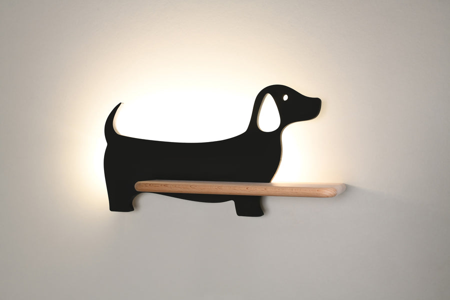 Applique noire allumée sur fond beige, lumière chaude diffusée vers le haut