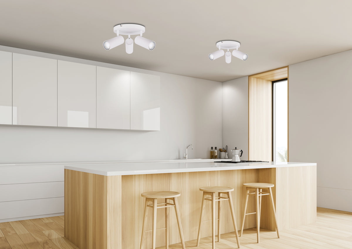 Mise en ambiance cuisine moderne, deux plafonniers blancs au-dessus d'un îlot central.
