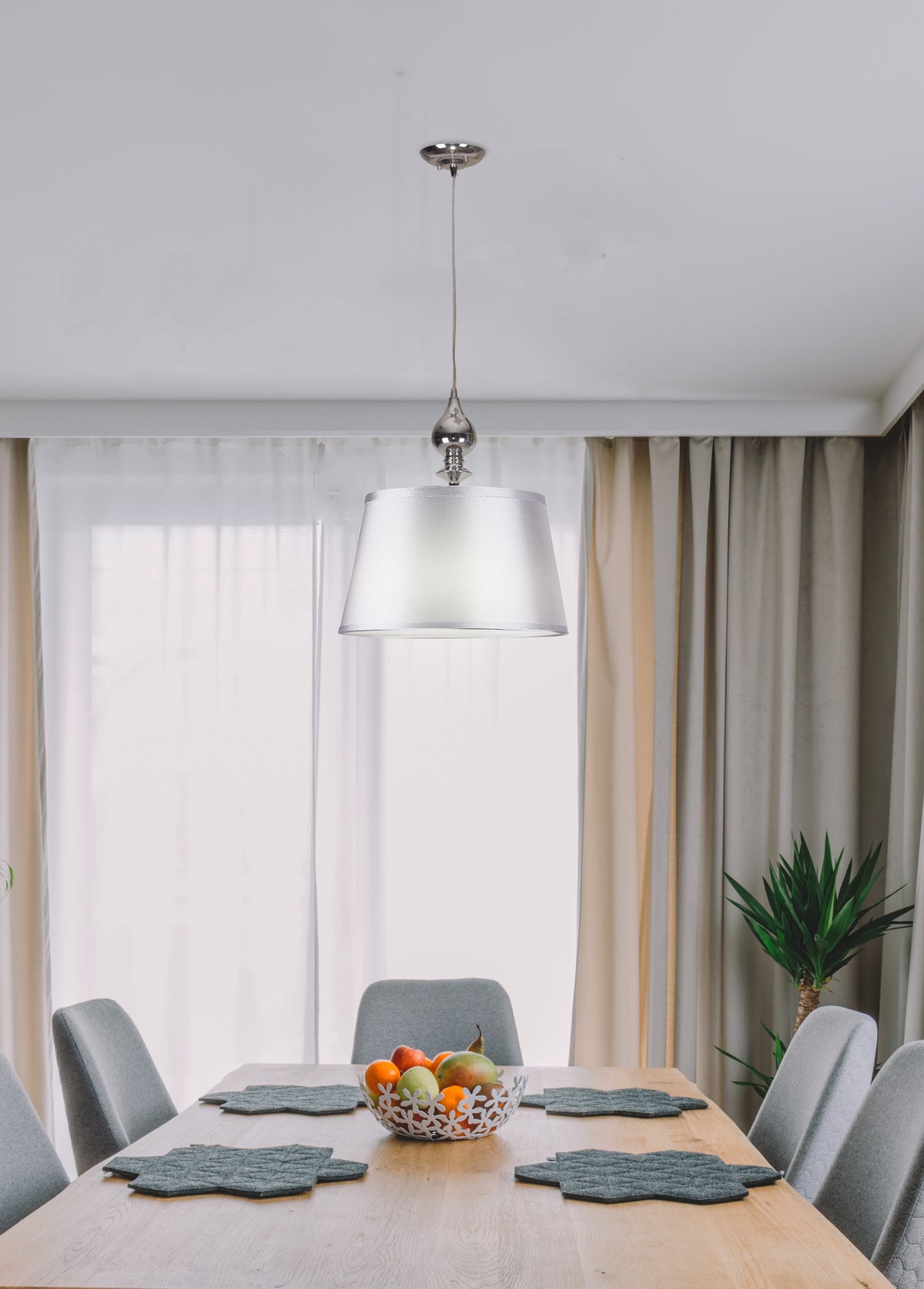 Mise en ambiance : suspension au-dessus d'une table de salle à manger en bois clair