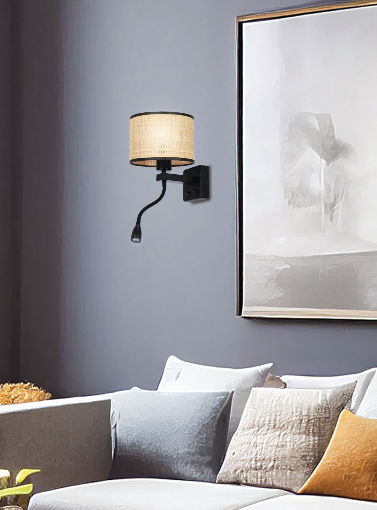 Mise en ambiance : applique allumée au-dessus d'un canapé gris avec coussins
