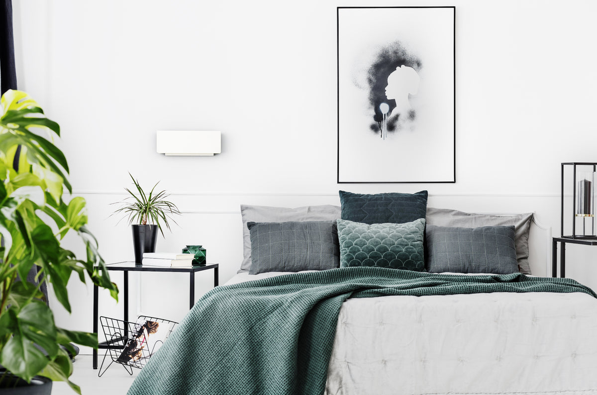 Mise en ambiance dans une chambre minimaliste, applique murale blanche fixée au-dessus du lit.