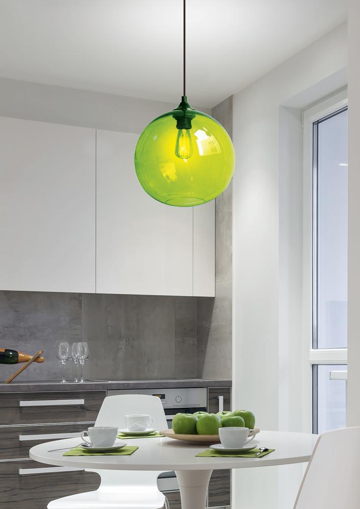 Suspension verte en verre suspendue dans une cuisine blanche, table dressée avec pommes vertes.