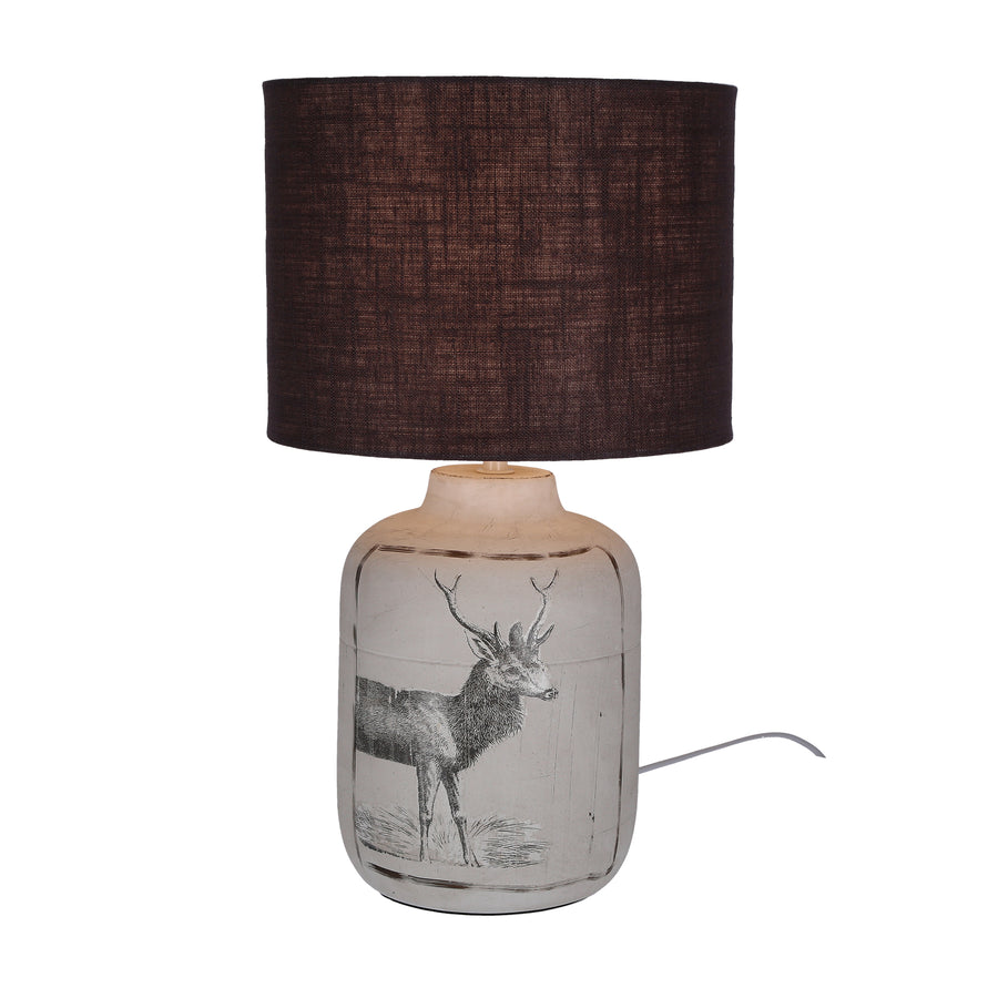 Même lampe allumée, mettant en valeur le cerf dessiné sur la base céramique