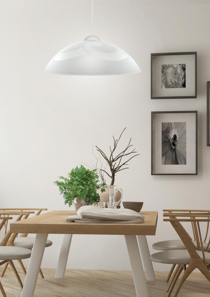 Vue rapprochée de l'abat-jour blanc suspendu éclairant la table dressée avec plantes et vaisselle