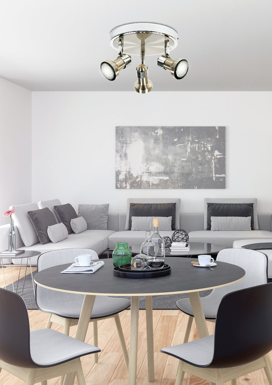 Luminaire installé au plafond au-dessus d'une table, dans un salon contemporain gris et bois clair.