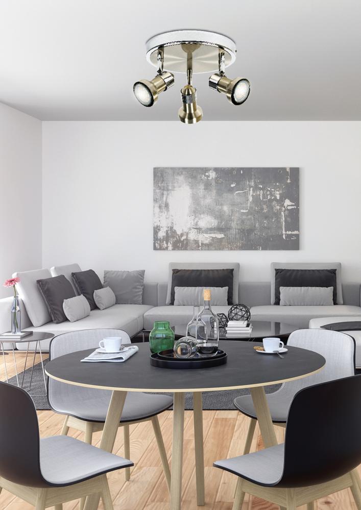 Vue d'ambiance du plafonnier allumé éclairant une salle à manger au décor gris et épuré.