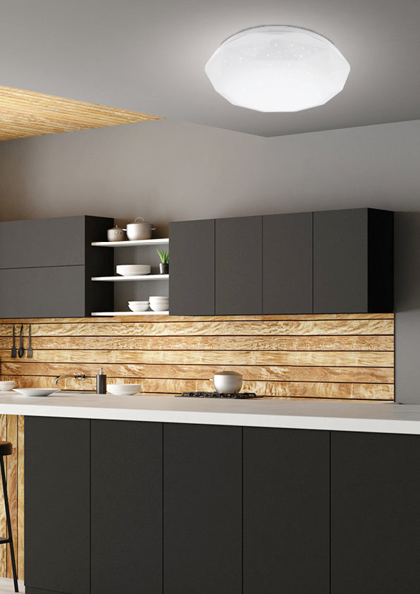 Mise en ambiance dans une cuisine moderne, plafonnier allumé au plafond au-dessus du plan de travail