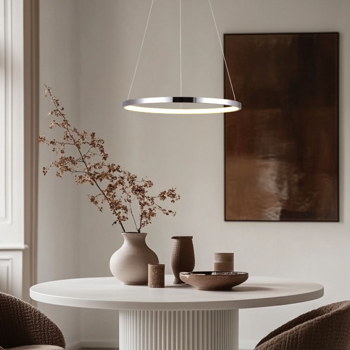 Mise en ambiance du luminaire au-dessus d'une table ronde avec vase et tableau