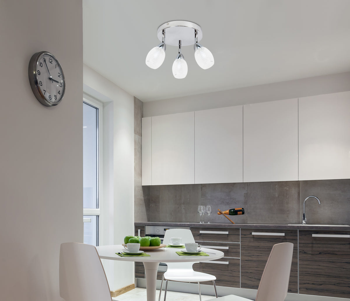 Mise en ambiance dans une cuisine moderne avec le plafonnier allumé au-dessus de la table.