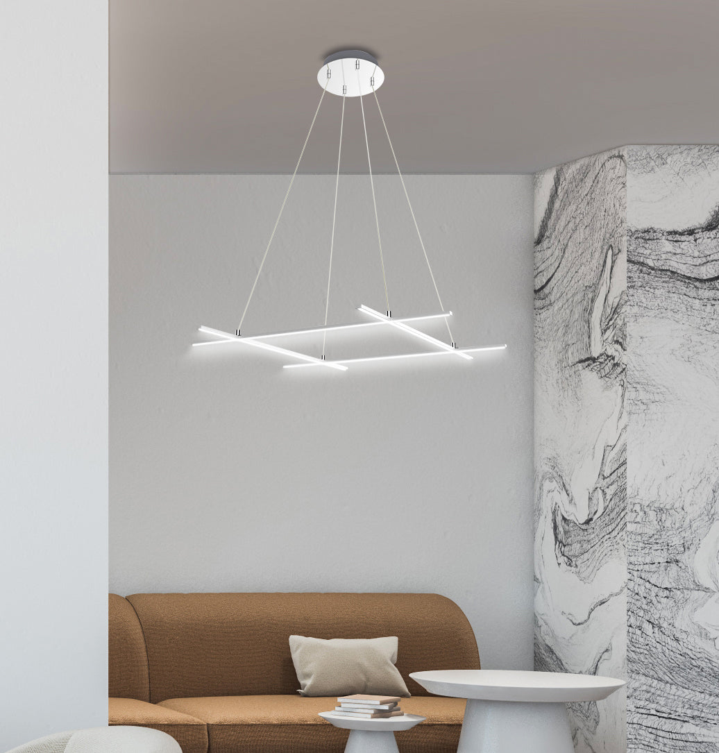 Mise en ambiance dans un salon, luminaire suspendu au-dessus d'un canapé beige et mur marbré