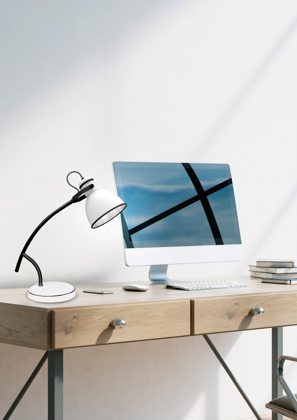 Lampe posée sur un bureau devant un ordinateur, ambiance studieuse.