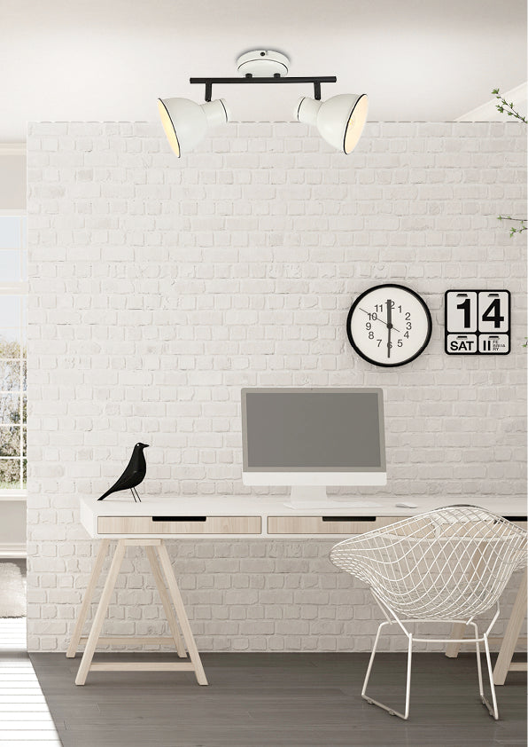 Mise en ambiance bureau avec plafonnier allumé, mur en briques blanches et horloge