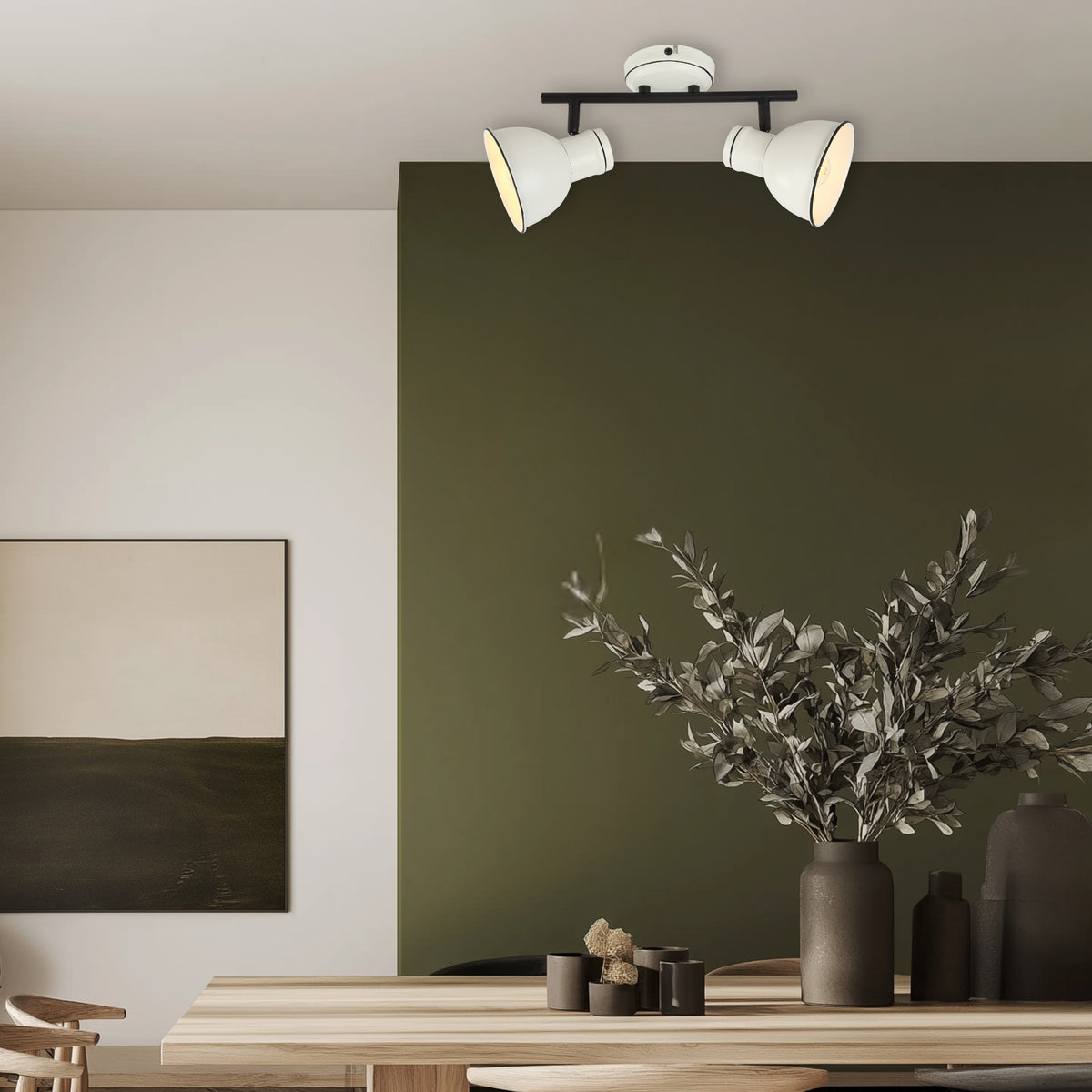Salle à manger avec plafonnier blanc et noir, mur vert, table en bois et vase