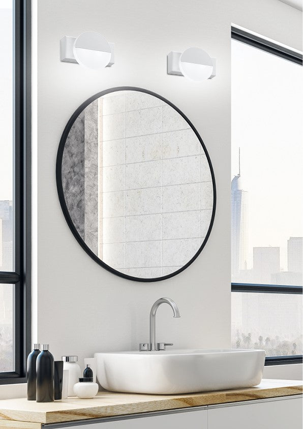 Mise en ambiance dans une salle de bain avec deux appliques au-dessus d'un miroir.