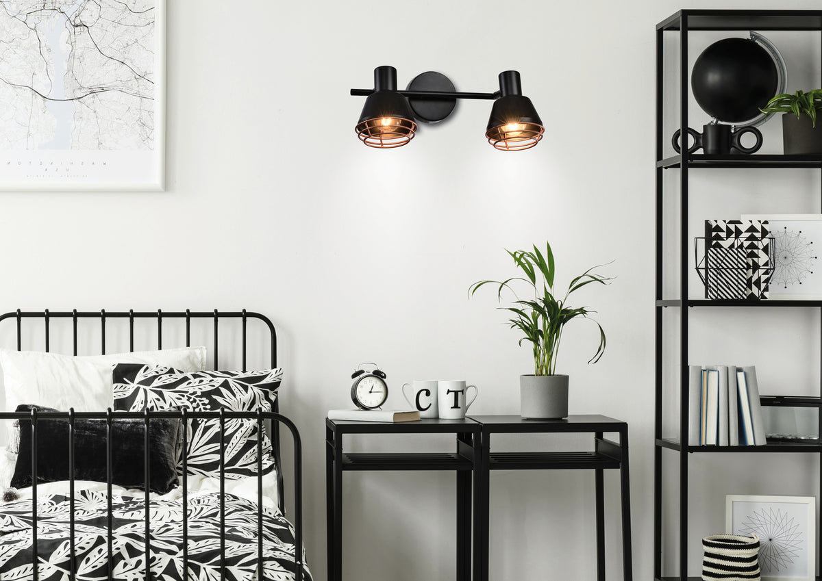 Mise en ambiance du spot mural dans un intérieur noir et blanc, près du lit.