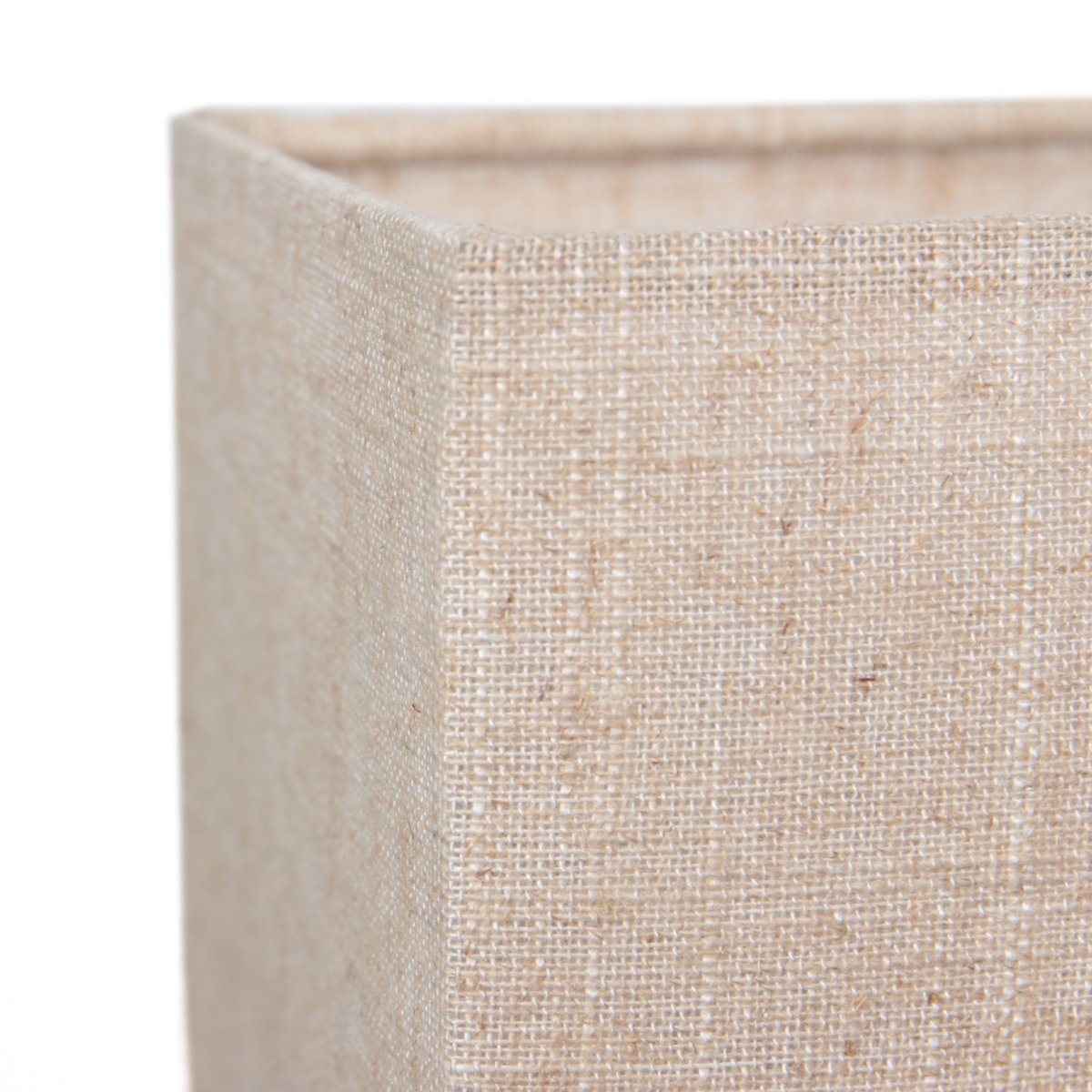 Gros plan sur l'angle de l'abat-jour en tissu beige texturé.