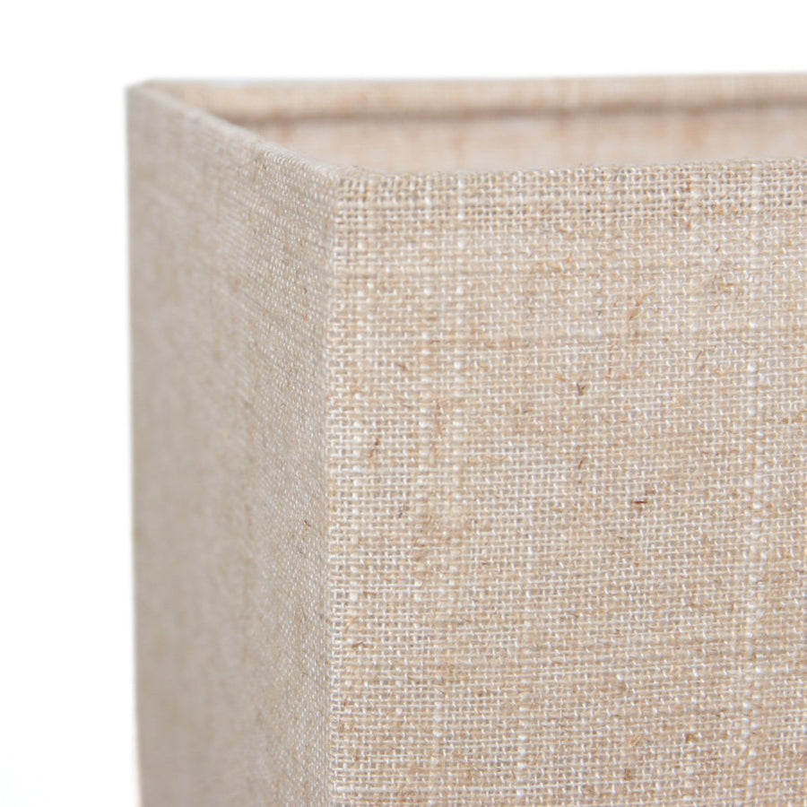 Gros plan sur l'angle de l'abat-jour en tissu beige texturé.