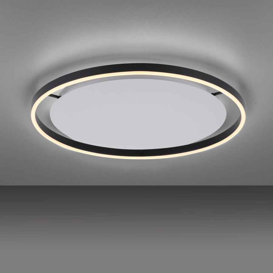 Plafonnier installé au plafond, anneau noir et halo lumineux blanc sur fond gris.