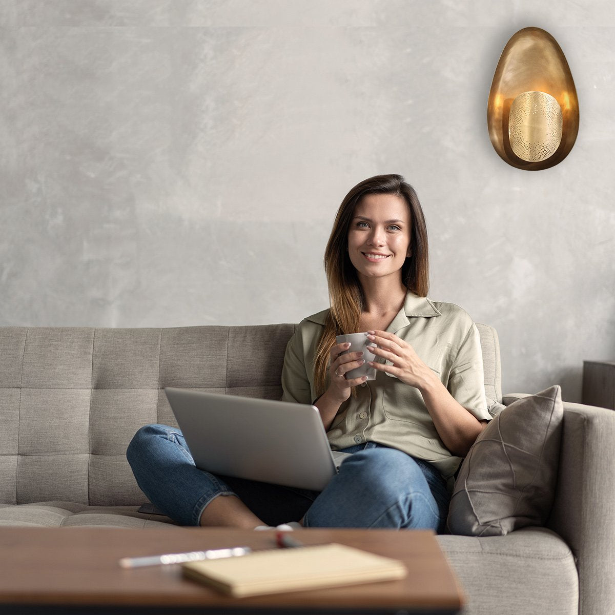 Mise en ambiance salon, femme assise lisant près du mur