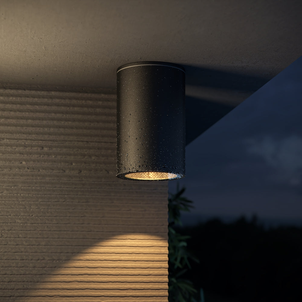 Mise en ambiance nocturne sous une pergola, spot éclairant un mur strié