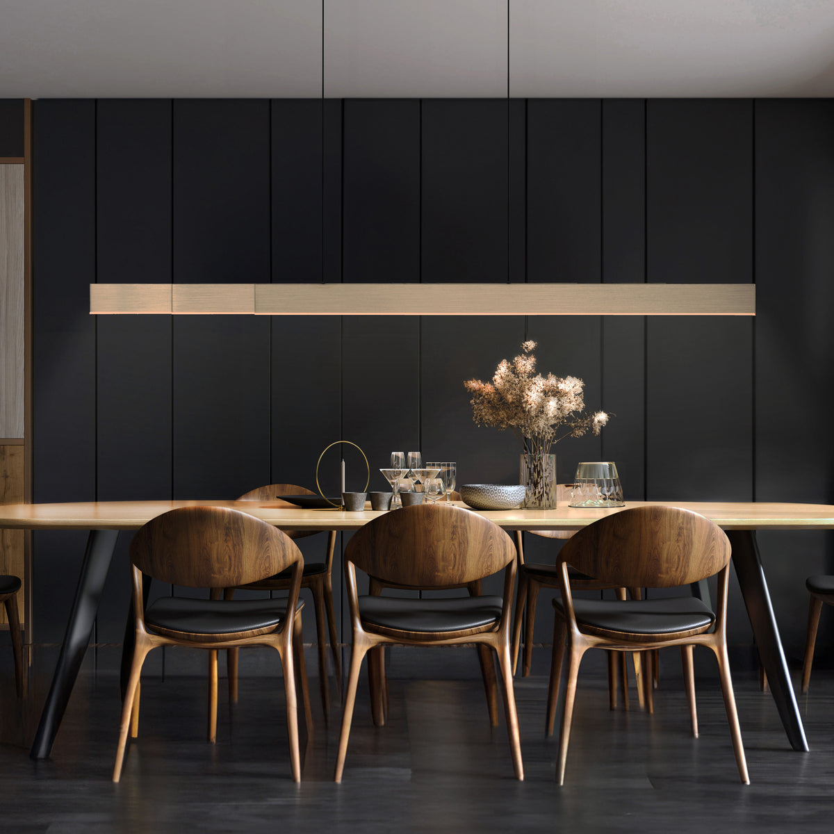 Mise en ambiance : suspension allumée au-dessus d'une table à manger en bois, intérieur sombre.