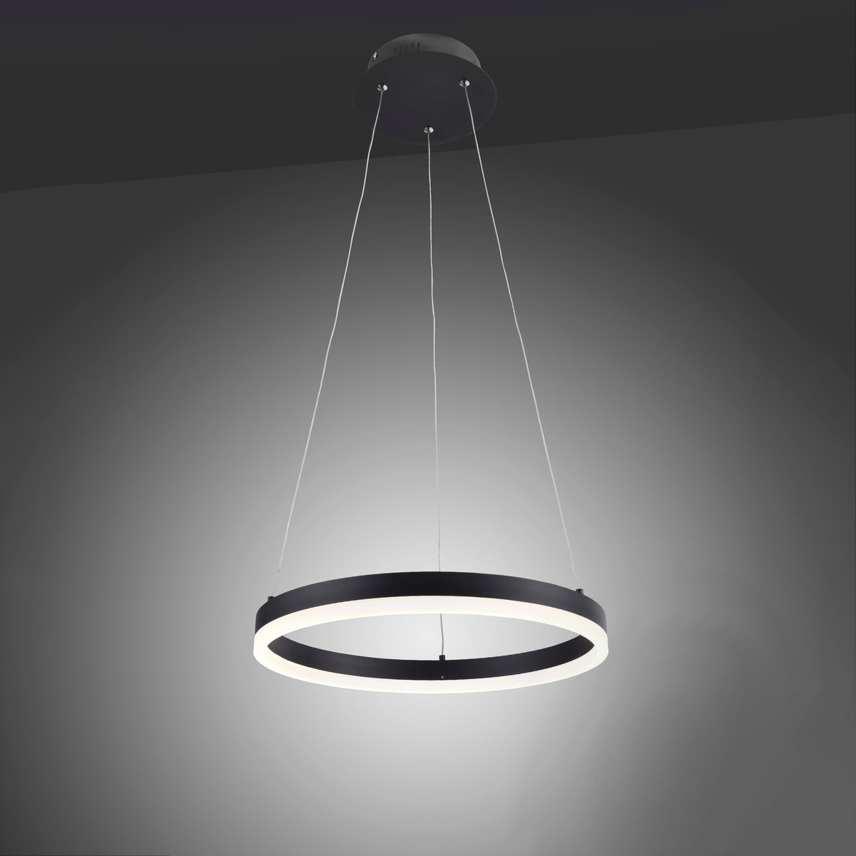 Luminaire allumé dans une pièce sombre, halo de lumière blanche chaude au plafond