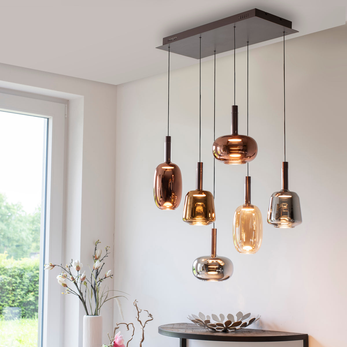 Mise en ambiance au-dessus d'une console en bois dans un intérieur lumineux.