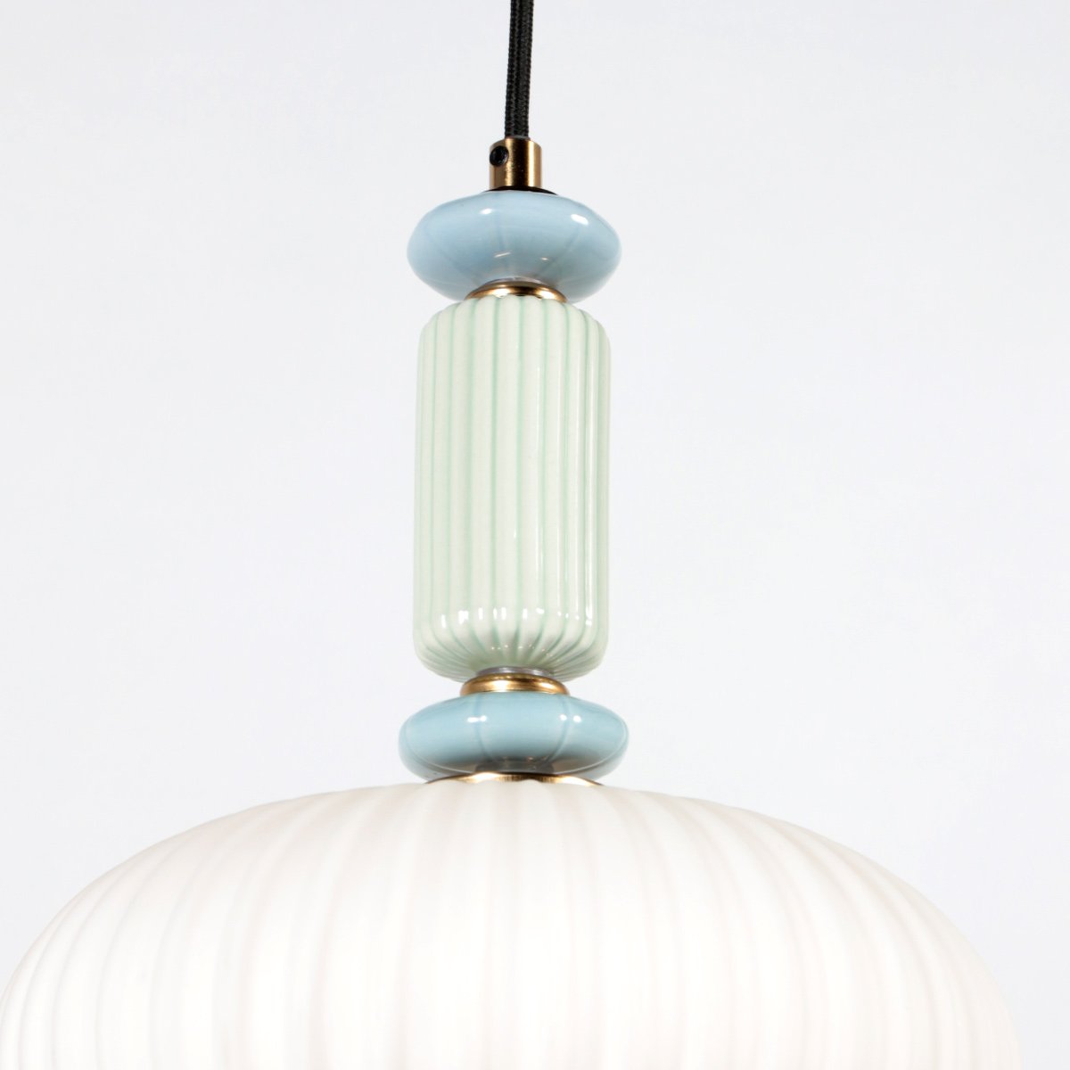 Détail du haut du luminaire montrant les anneaux bleus, la tige cannelée et les finitions dorées.