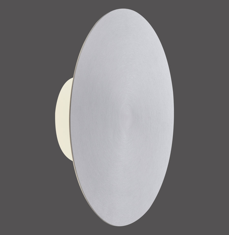 Vue de profil sur fond gris de l'applique murale ronde en aluminium allumée.