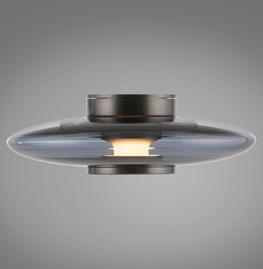 Vue de profil du luminaire allumé, disque de verre fumé et capot métallique