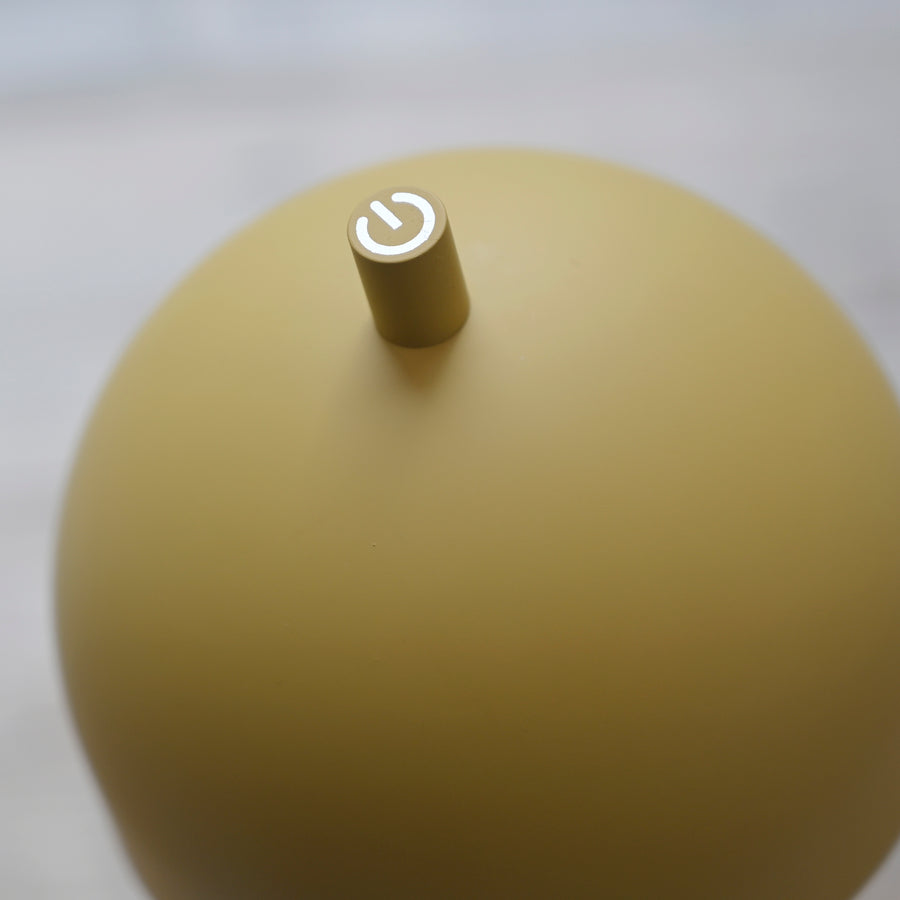 Détail du bouton tactile placé en haut de l'abat-jour jaune