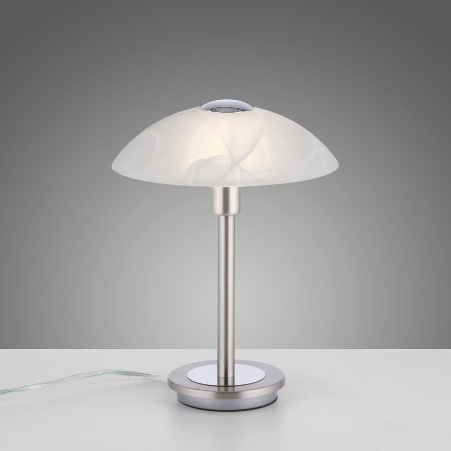 Lampe allumée posée sur table, câble transparent visible sur le côté